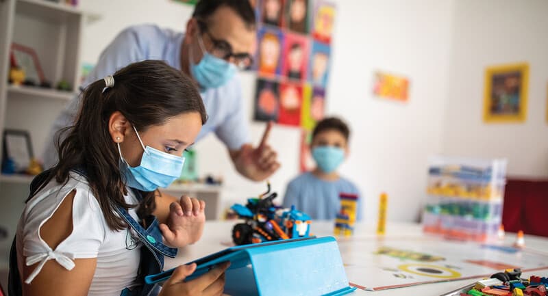 teacher and students in classroom wearing masks