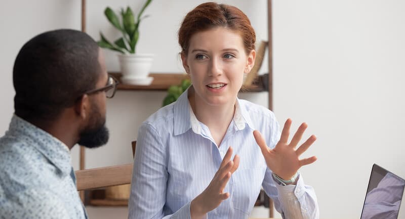 Photo of two teachers talking in front of a laptop