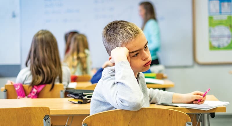 Photo of a student looking distracted in class