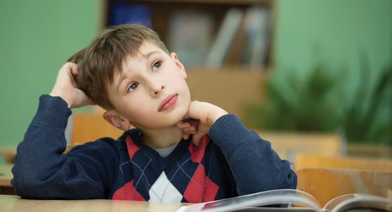 Photo of a young student looking confused in class