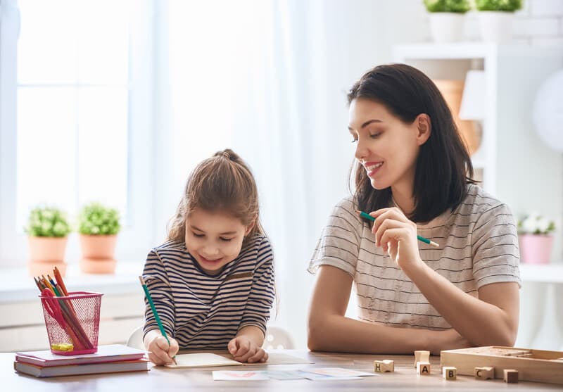 Photo of an adult helping a young child with schoolwork